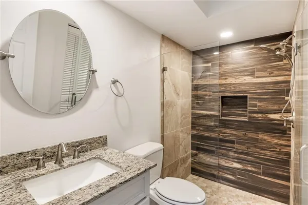 a bathroom with a granite countertop toilet sink and shower