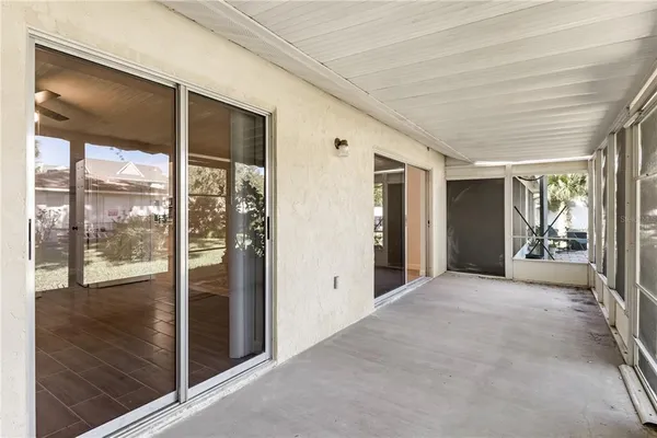 a view of a hallway with wooden floor and a porch