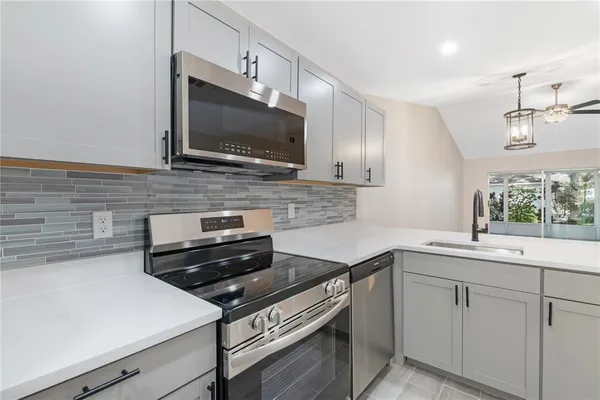 a kitchen with a sink stove and microwave