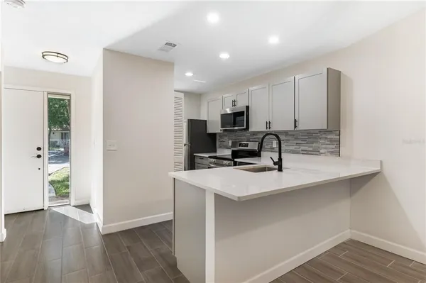 a kitchen with kitchen island a sink appliances and cabinets