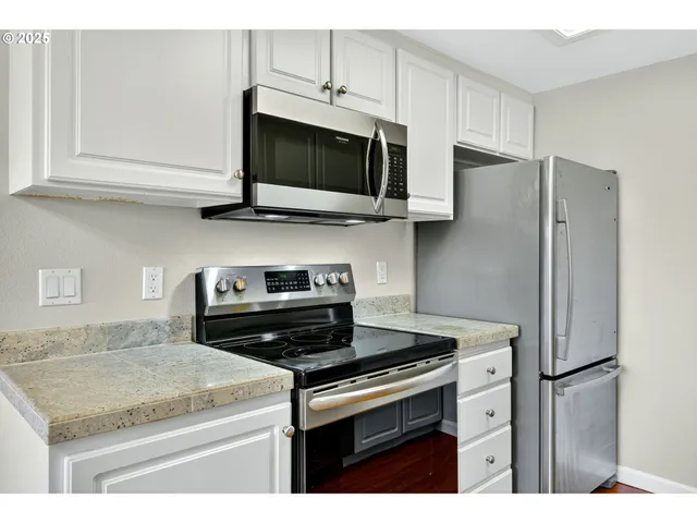 a view of an empty room with wooden floor and closet
