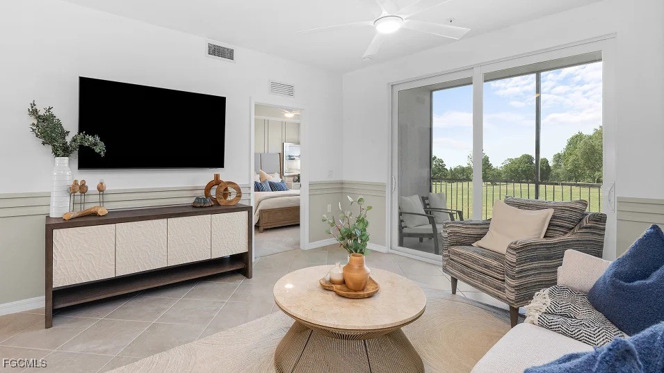 43985 Boardwalk Loop, Unit 2135 Punta Gorda, FL 33982 - Photo 11 of 48 a living room with furniture a flat screen tv and a floor to ceiling window