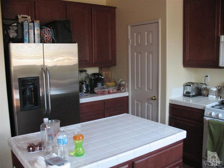 1420 Quincy Street Oxnard, CA 93033 - Photo 5 of 27 a kitchen with stainless steel appliances kitchen island a refrigerator a sink a stove and cabinets