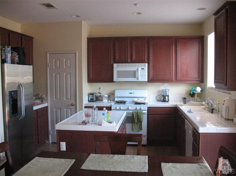 1420 Quincy Street Oxnard, CA 93033 - Photo 8 of 27 a room with a sink wooden cabinets and stainless steel appliances