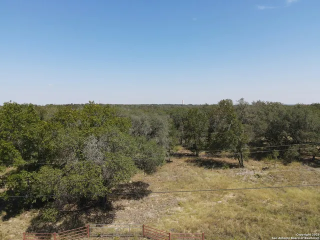 a view of a dry yard with wooden fence