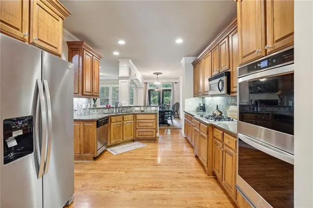 a large kitchen with stainless steel appliances and large windows
