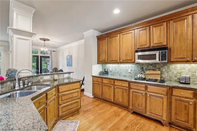 a kitchen with stainless steel appliances granite countertop a sink stove and cabinets