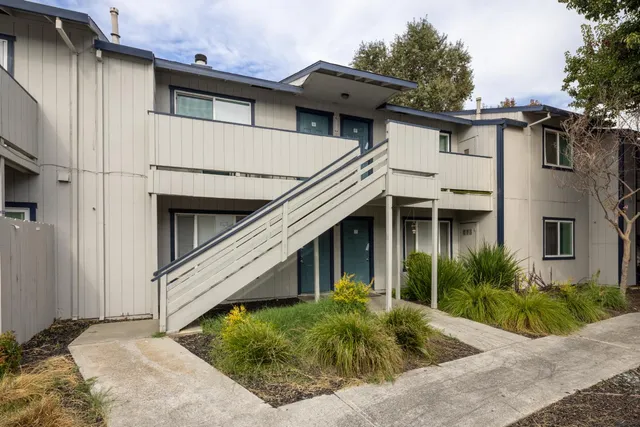 a view of a white house next to yard