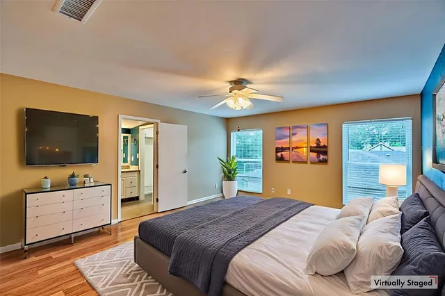a bedroom with a large bed and a flat tv screen on dresser
