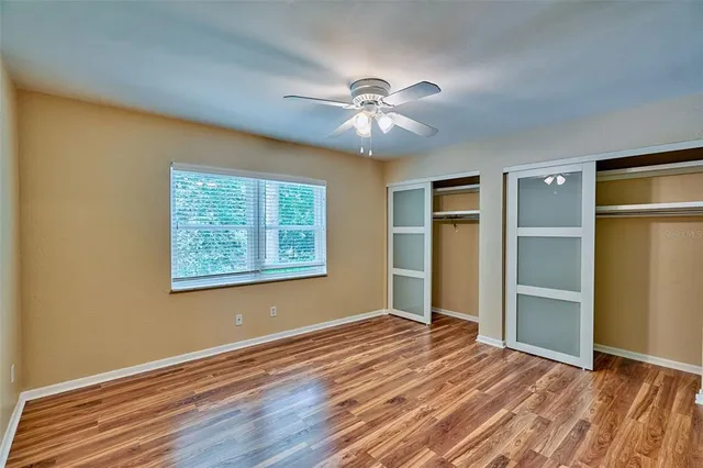 a view of an empty room with window and wooden floor
