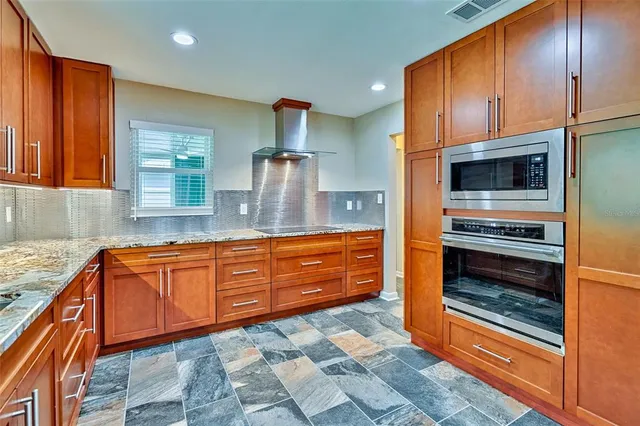 a kitchen with granite countertop stainless steel appliances and wooden cabinets
