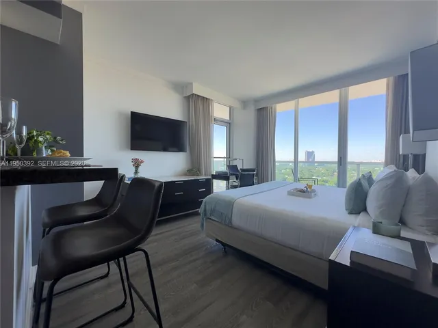 a bedroom with a bed window and a chair