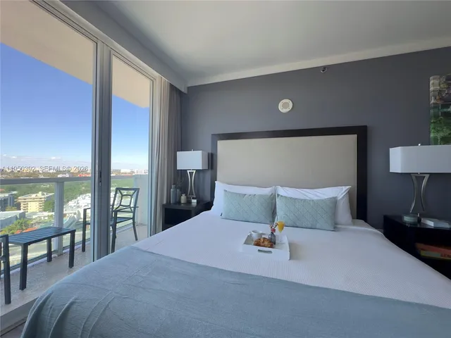 a bedroom with a large bed and a lamp on table