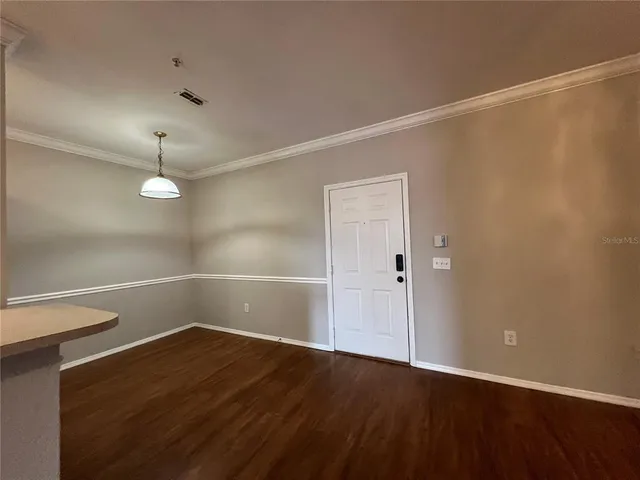 a view of a room with wooden floor and white walls