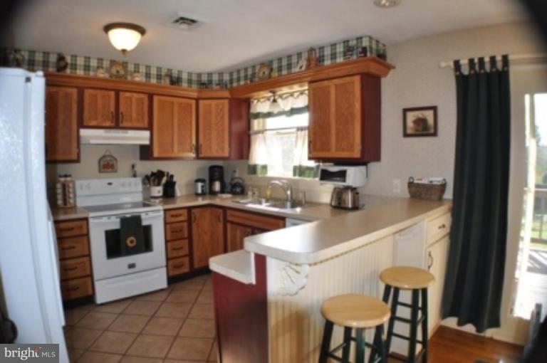 4807 Dave Rill Road Hampstead, MD 21074 - Photo 5 of 25 a kitchen with a stove a sink and a refrigerator
