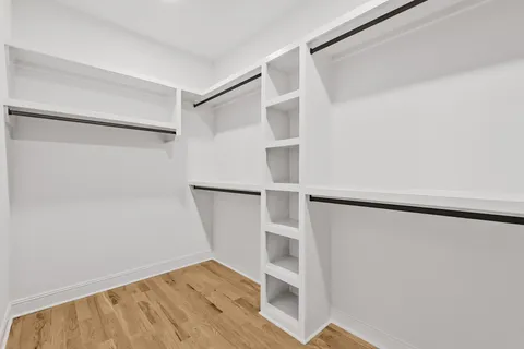 a view of walk in closet with empty racks