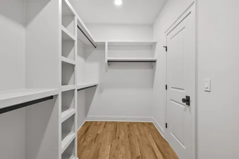a view of walk in closet with empty racks