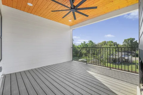 a view of a balcony with wooden floor and fence