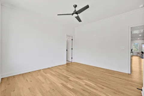 a view of a room with wooden floor and a ceiling fan