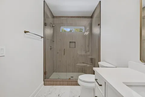 a bathroom with a sink a toilet and shower