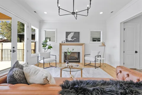 a living room with furniture a fireplace and a floor to ceiling window