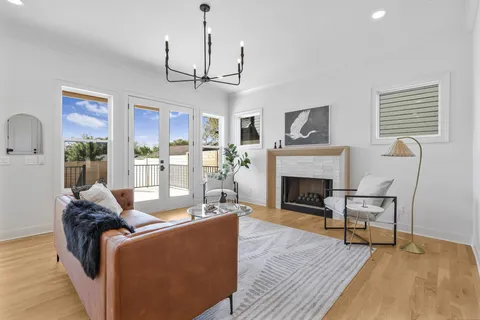 a living room with furniture a fireplace and a chandelier
