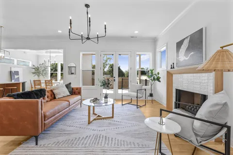 a living room with furniture a fireplace and a chandelier