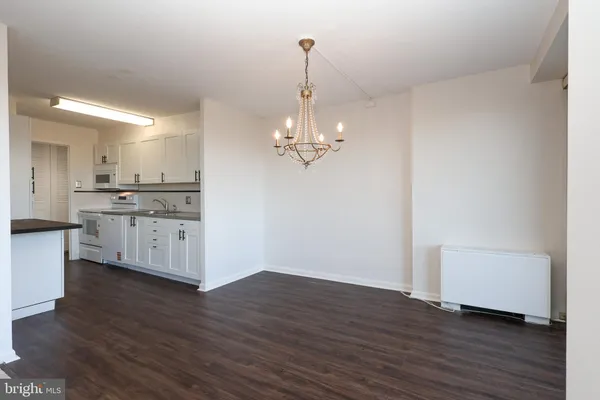 a view of a kitchen with stainless steel appliances granite countertop a dishwasher a stove and a wooden floor