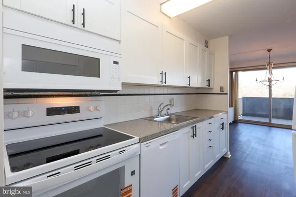 a kitchen with granite countertop cabinets stainless steel appliances and wooden floor