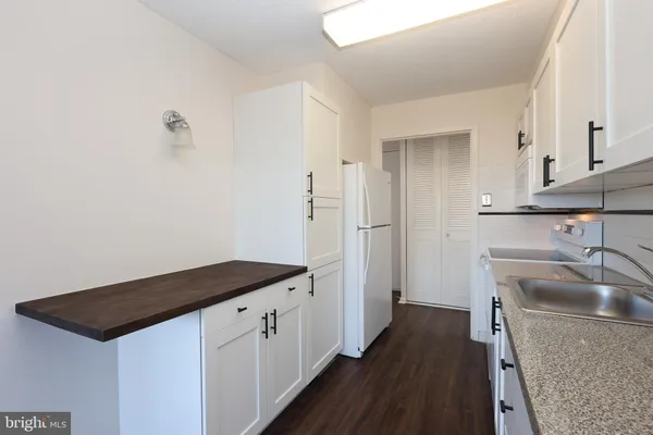 a kitchen that has a sink a stove and a refrigerator