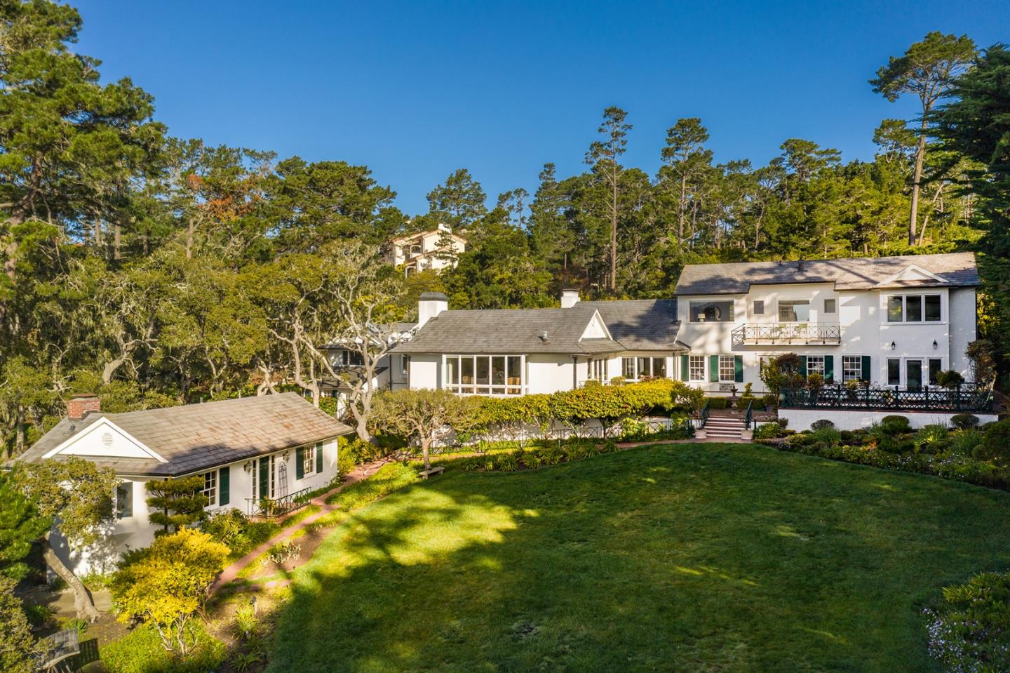 1476 Bonifacio Road Pebble Beach, CA 93953 - Photo 29 of 39 a view of a white house with a big yard and potted plants
