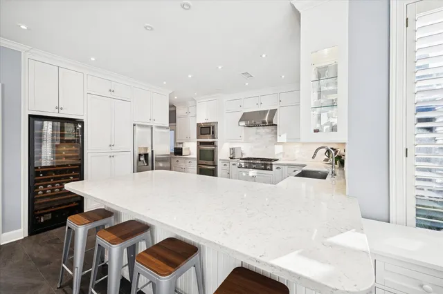 a living room with stainless steel appliances furniture a dining table and kitchen view