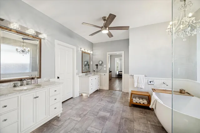 a spacious en suite bathroom with a double vanity sink mirror and bathtub