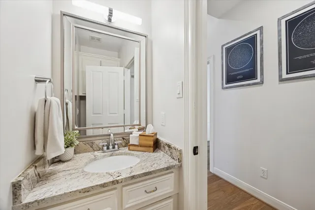 a bathroom with a granite countertop sink and a mirror