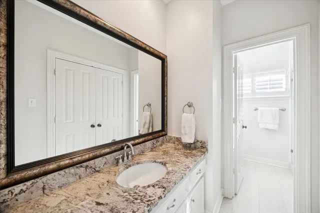 a bathroom with a granite countertop sink and a mirror