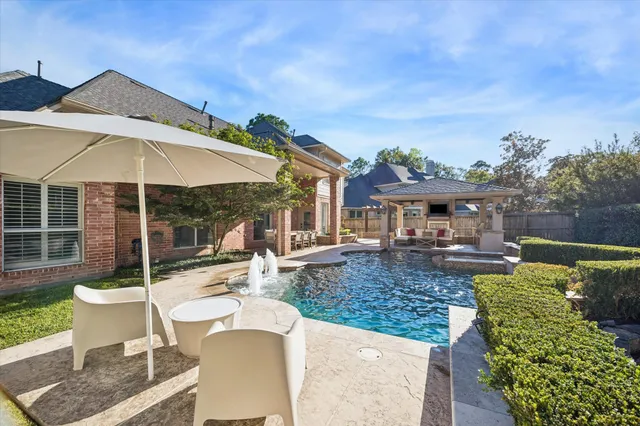 a view of a house with backyard sitting area and swimming pool