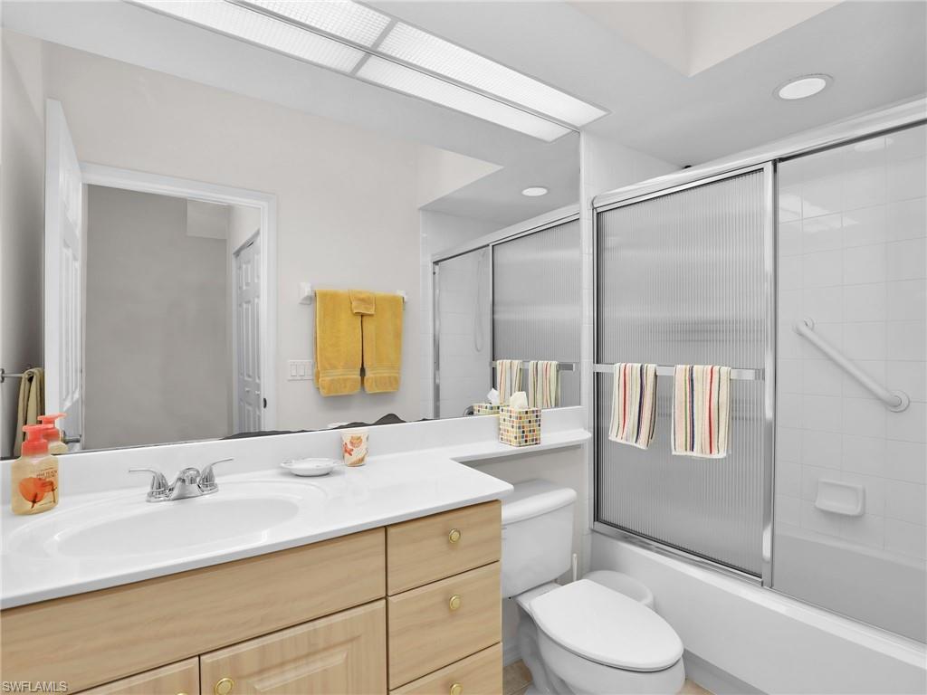 23731 Eddystone Road, Unit 6204 Estero, FL 34135 - Photo 25 of 30 a bathroom with a granite countertop sink toilet a mirror a vanity and shower