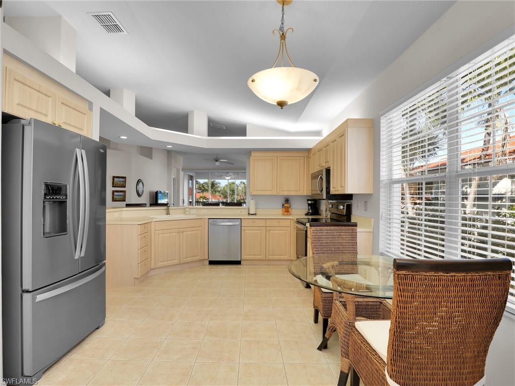 23731 Eddystone Road, Unit 6204 Estero, FL 34135 - Photo 10 of 30 a kitchen with refrigerator cabinets and chairs