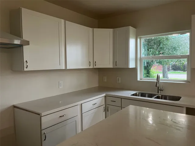 a kitchen with a sink cabinets and window