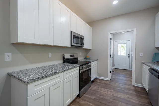 a kitchen with granite countertop wooden cabinets and a stainless steel appliances
