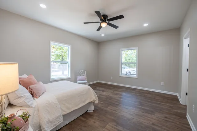a bedroom with a large bed window and a chandelier