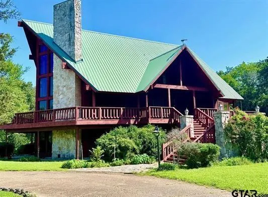 a view of a house with a yard and potted plants