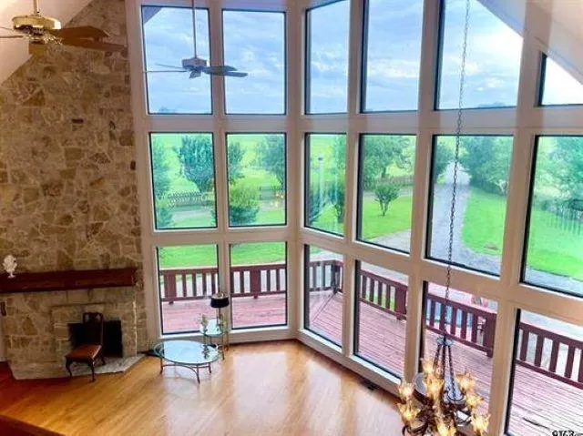 a view of an empty room with a floor to ceiling window and wooden floor