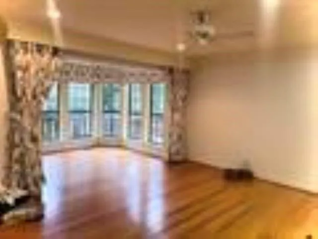 a view of room with floor to ceiling window and wooden floor