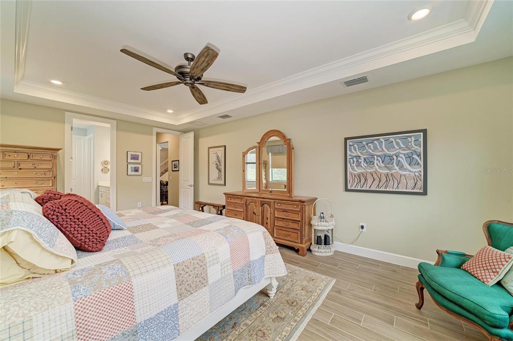 16341 Hidden Oak Loop Lakewood Ranch, FL 34211 - Photo 26 of 76 a bedroom with a bed and dresser with wooden floor