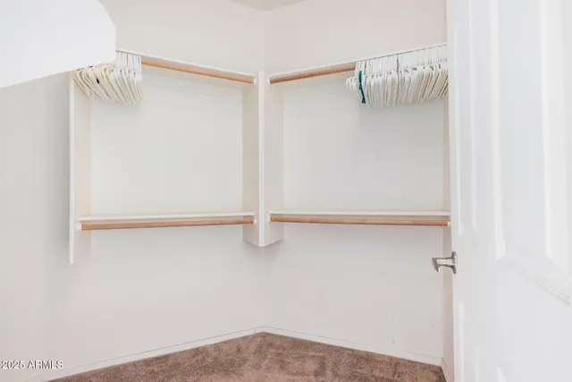 a view of walk in closet with empty racks