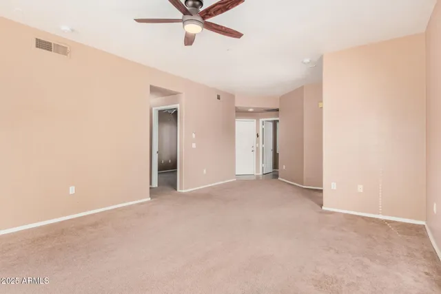 a view of a livingroom with a ceiling fan and window