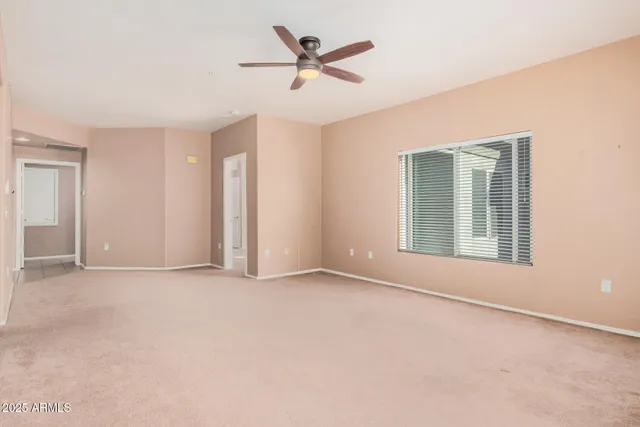 an empty room with fan and windows