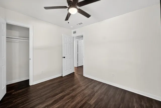 a view of an empty room with wooden floor