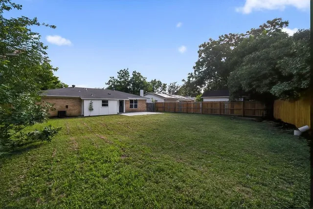 a front view of house with yard and trees in the background